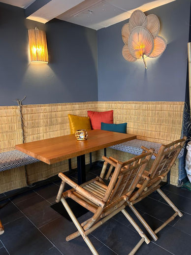 Rincón acogedor de café con mesa, banco y sillas de madera, restaurante sin gluten en sevilla