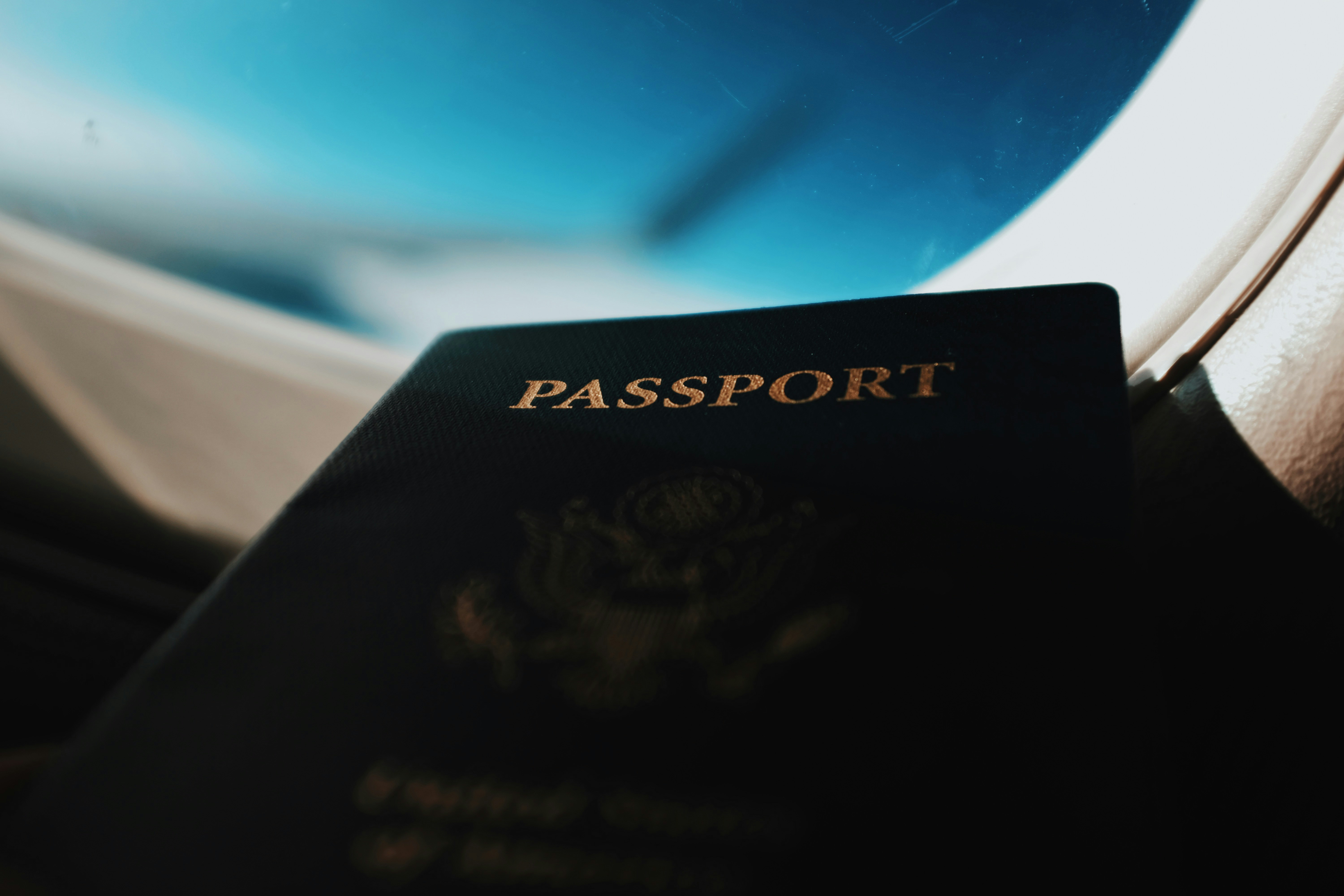 Passport held up against an airplane window