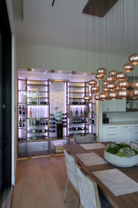 Custom wine wall Miami featuring glass enclosure, illuminated bottle displays, and contemporary luxury wine storage by Dragon Cellars