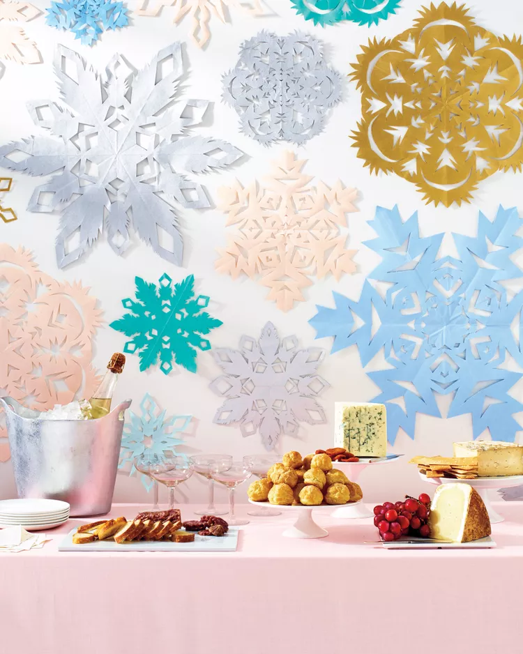 multi coloured, pastel paper snowflakes behind a festive Christmas food buffet 