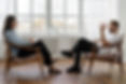 A man and a woman in comfortable chairs, facing each other in a coaching session. Picture thanks to pexels-cottonbro-4101143