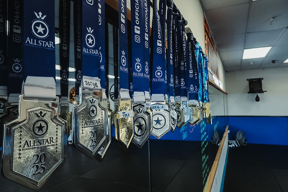 Row of All Star BJJ medals for 2025 hung in a gym.