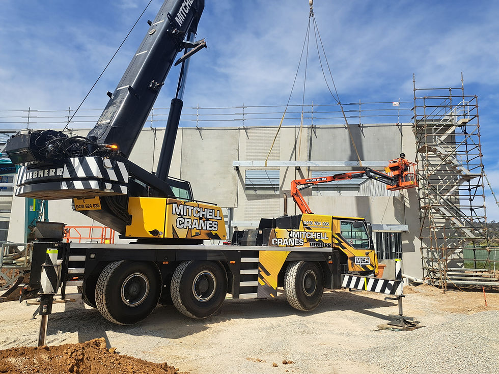 Mobile crane lifting precast concrete wall panels on a construction site in Canberra