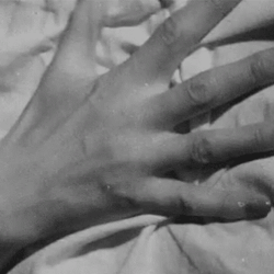 hand-clutching-the-sheets-black-and-whit