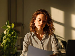 A slightly confused woman looking at paperwork