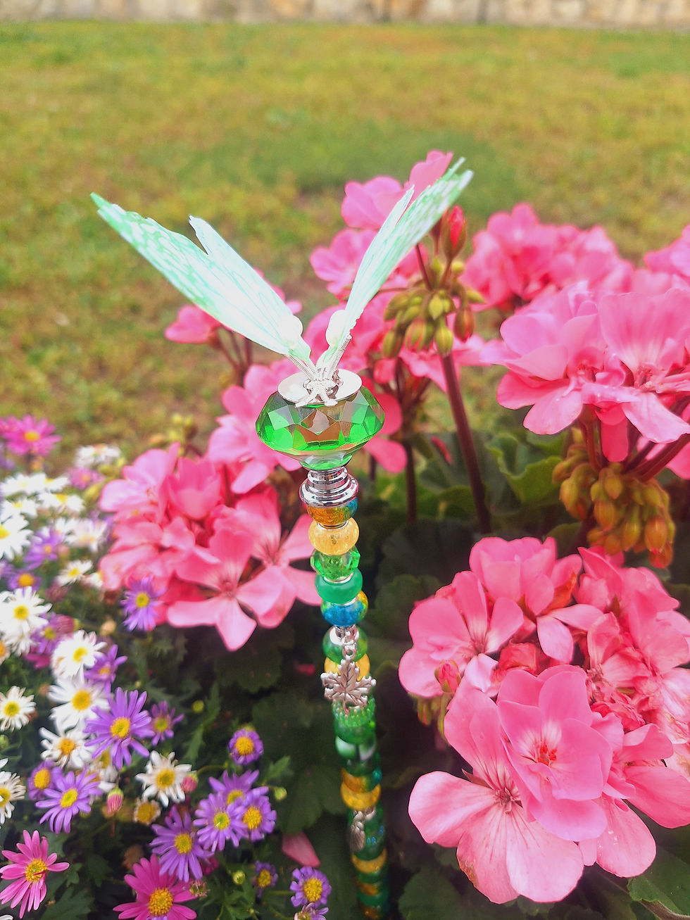 Miniaturbild: Dekorativer Gartenstecker mit hellgrünen Schmetterling Gartenstecker zwischen rosa und lila Blüten.