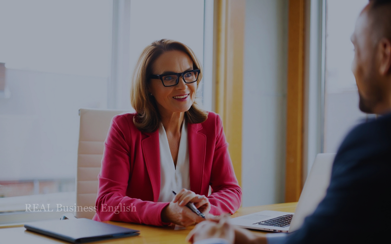 Two business professionals discussing progress during a meeting in a modern office.