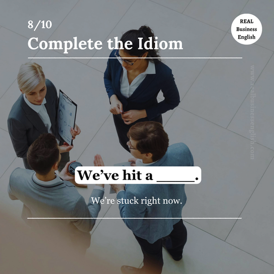 Business English idiom quiz card with the sentence We’ve hit a wall, showing a workplace team discussion and an idiom about being stuck and unable to move forward.