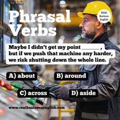 Poster for a Business English phrasal verbs quiz. The image shows a factory worker in a yellow hard hat looking at control screens, with the sentence Maybe I didn’t get my point _____, but if we push that machine any harder, we risk shutting down the whole line. The multiple-choice answers are about, around, across, and aside, and the image includes the Real Business English branding and website URL.