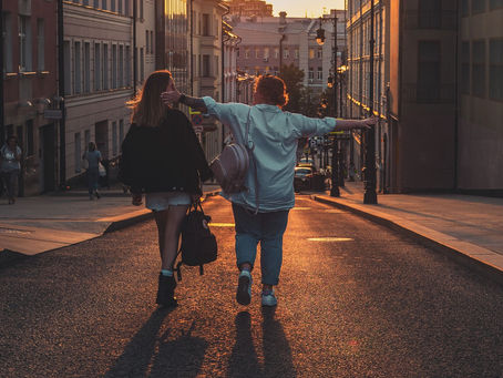 two women walking confidently down a sunlit street at golden hour