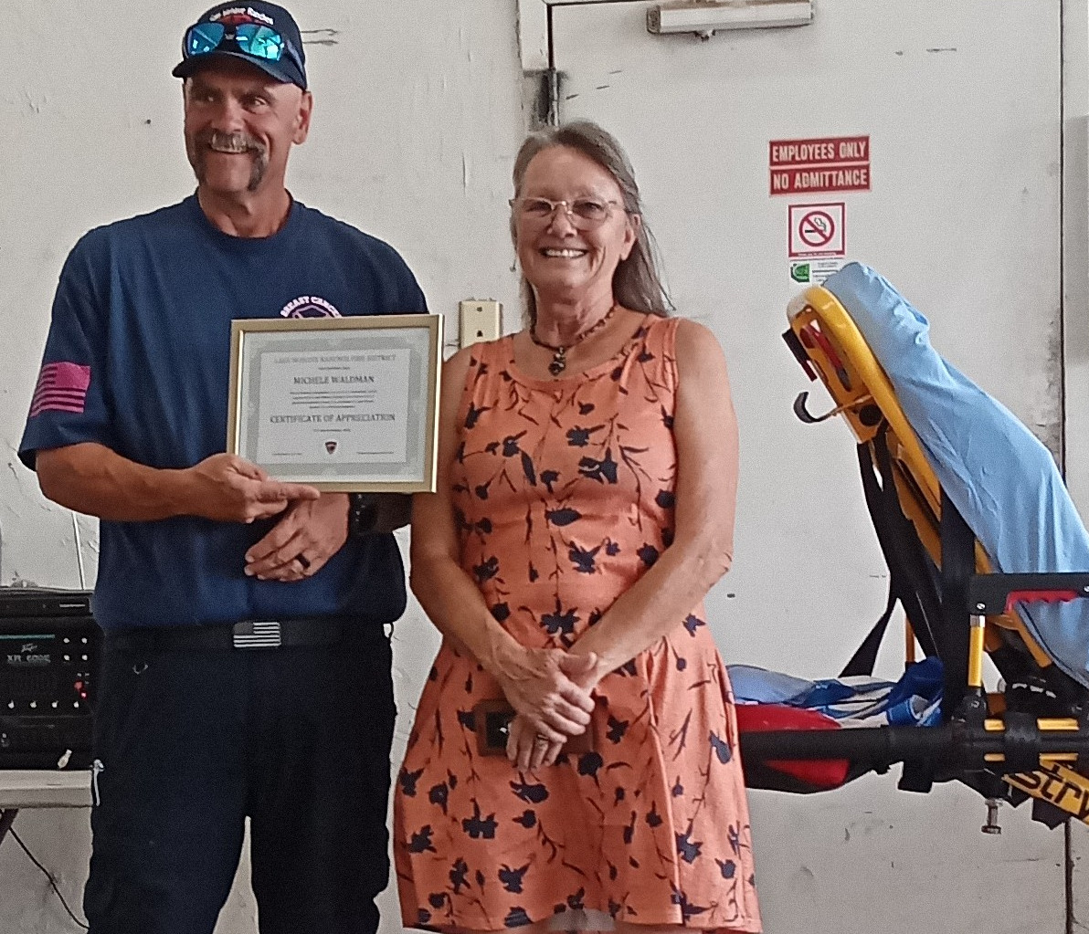 Chief Bonnee presenting Certificate of Appreciation to Michele Waldman for her $10,000 donation to the power gurney.