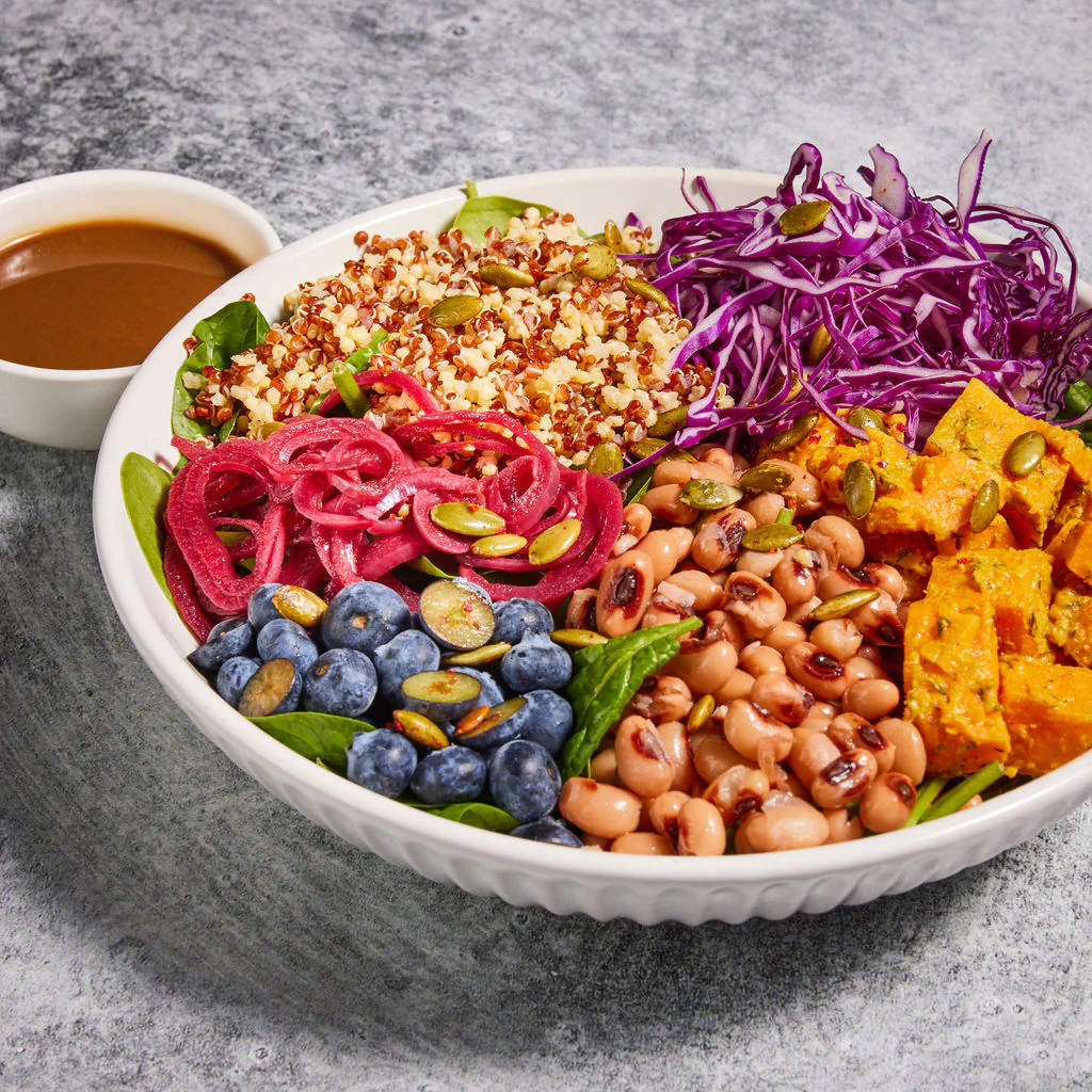 Colorful grain bowl with blueberries, red onions, sweet potatoes, beans