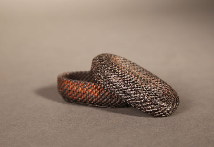 A dark brown, oval shaped, binali basket