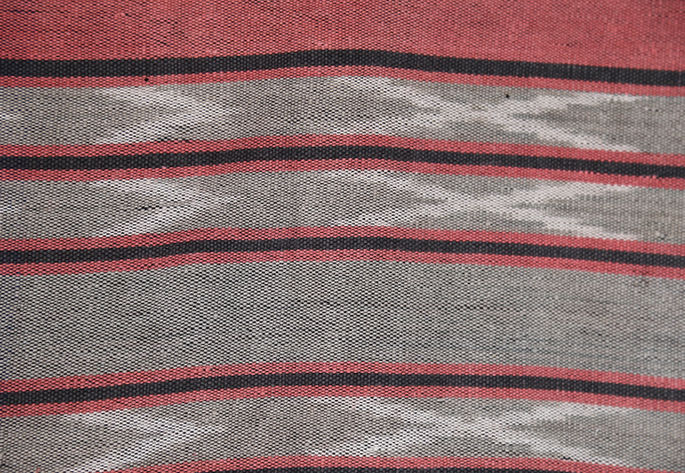 A close-up shot on the “V” and “X” motifs that are interspersed with red and black stripes design