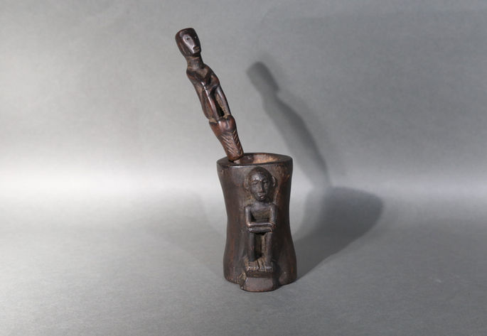 A miniature mortar and pestle with an anthropomorphic figure carved on the wooden mortar. Another anthropomorphic carving is attached to its  metal pestle.

Measurement/Item Physical Dimensions: 

Mortar
Height: 7cm

Mortar’s Rim
Diameter: 3cm x 3cm

Pestle
Length: 14.3cm