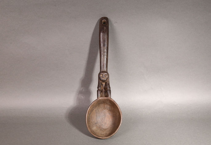 A wooden ladle with an anthropomorphic figurine handle