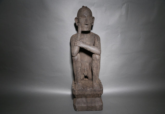 A seated male bulul with encrusted patina