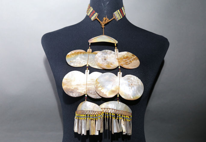 An example of sipatal with four butterfly-shaped shell pendants