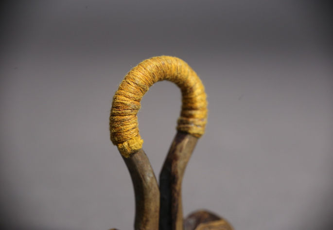 A yellow thread mounted on the curve of the earring findings