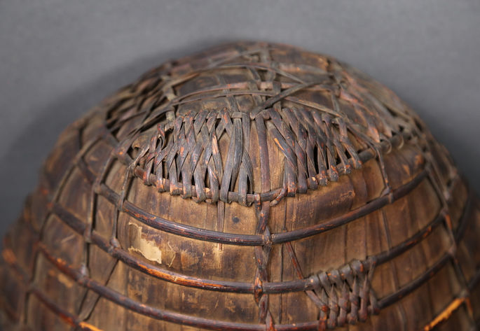 A closer look the top of the rain cape that shows the details of rattan weaving that was used to shape the basket