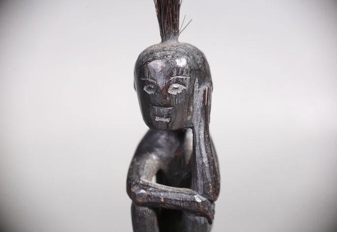A closer look at the tangkil’s wooden human figurine carved like its left hand is on its cheek
