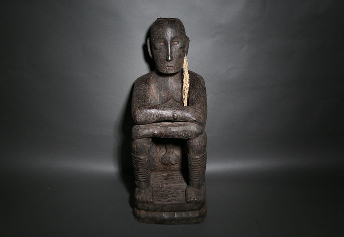 A sitting bulul with rice stalks on its ear