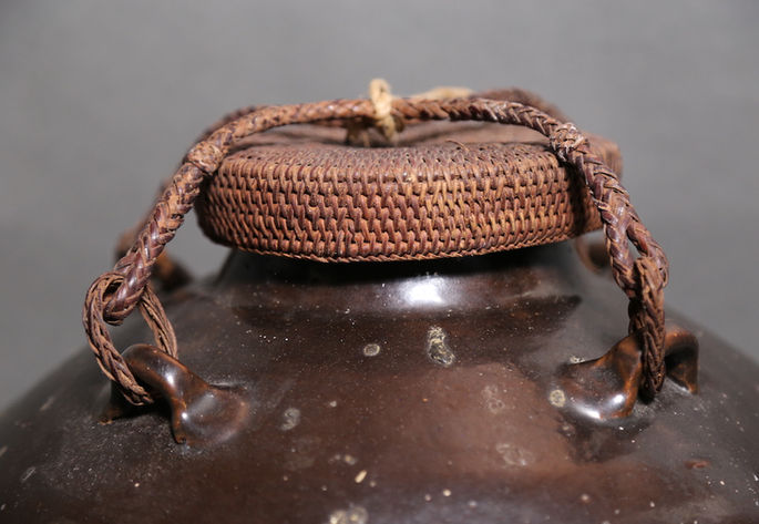 A circular woven rattan lid of the jar