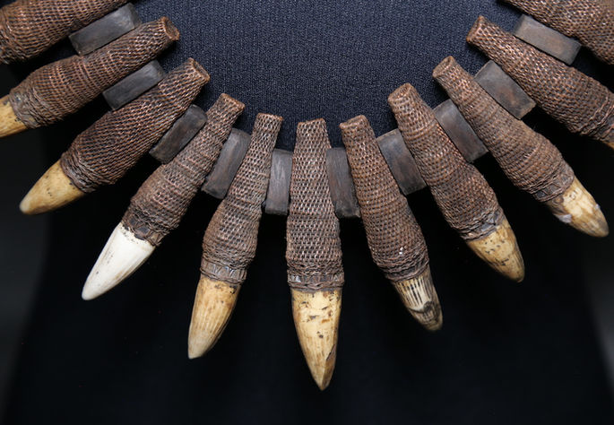 Between the basket works that hold the boar’s teeth are tiny wooden cubes that separate each teeth ornamentation