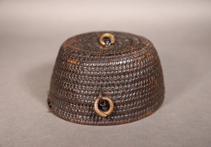 A woven hat with brass metal