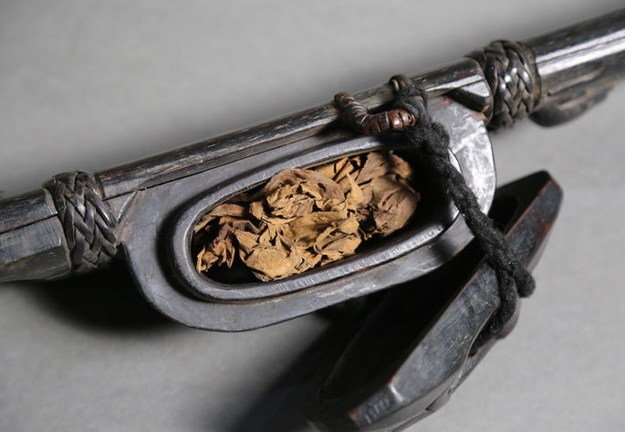 A closer look at the container attached to the bolo’s scabbard showing the dried tobacco inside