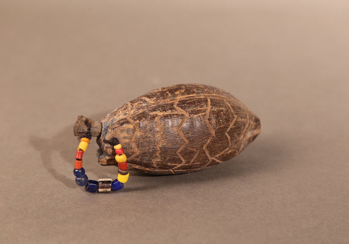 A tafayag made from a cacao shell adorned with beads