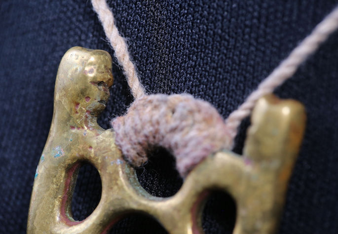 Identical anthropomorphic figures on both sides of the pendant