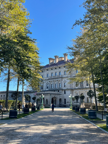 Breakers Exterior: Large pathway lined with trees to a three story mansion