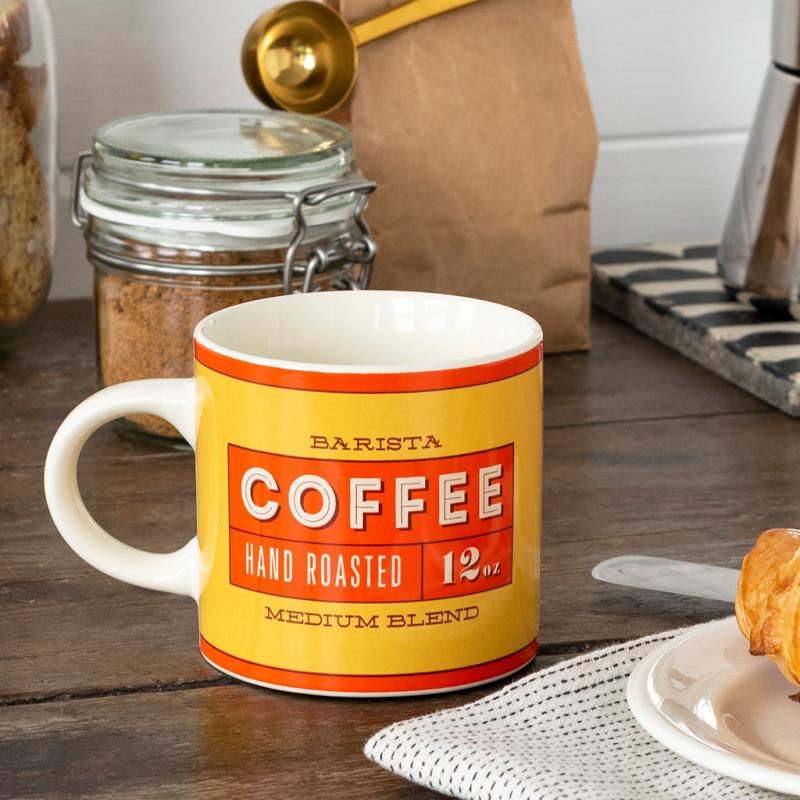 “Vintage coffee mug styled on rustic wooden surface with coffee beans”