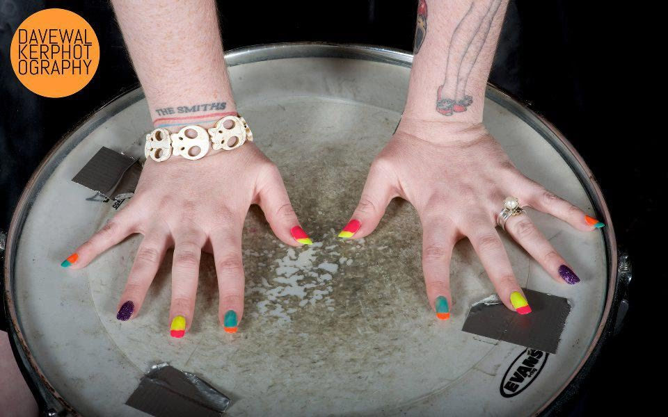 Thumbnail: White howlite skull bracelet on tattooed wrist with colourful neon nails – bold retro punk jewellery with goth and kitsch vib