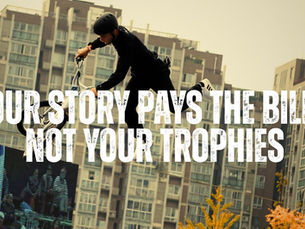 A photo of a BMX Freestyle Athlete with text that says your story pays the bills not your trophies