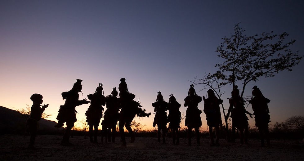 Himba dancers silhouetted by sunset