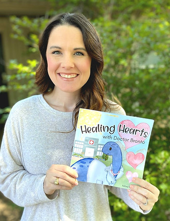 Kelsey holding the book Healing Hearts with Doctor Bronto