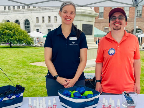 Kat Challis, Senior Director of Development at New Hampshire Children's Trust, and Colby Dudal, ABLE NH Board Member, smiling together at the Disability Pride Parade & Festival in downtown Concord, NH.