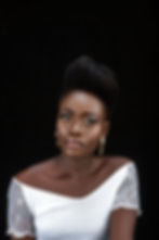Portrait of a black woman with an up-do hairstyle staring into the camera