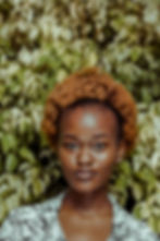 Portrait of a black woman with brown hair, staring into the camera