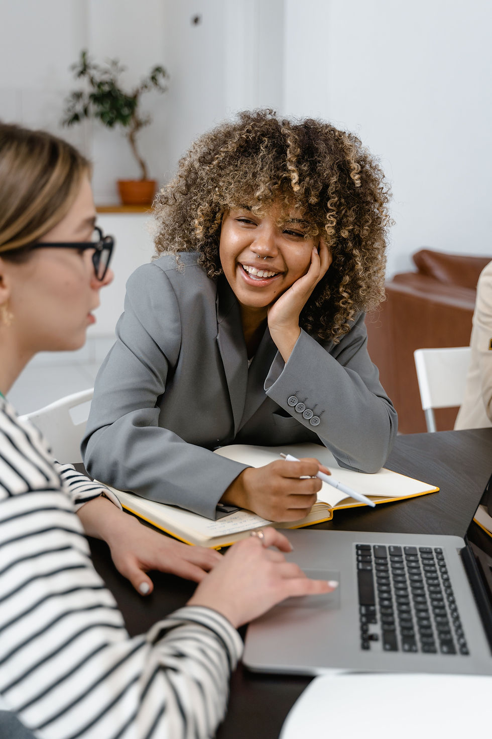 Photo focused on a woman smiling while talking to another woman