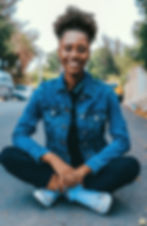 Portrait of woman sitting outside on the ground and smiling