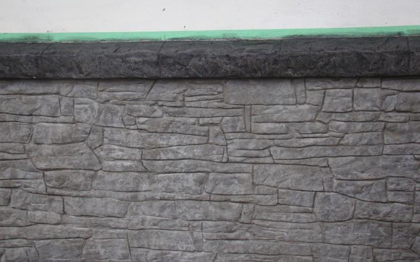 Vertical stamped concrete feature wall textured like stacked stone