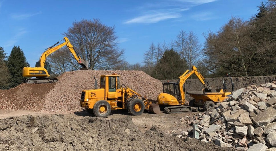 Yellow excavators and wheel loader moving aggregate