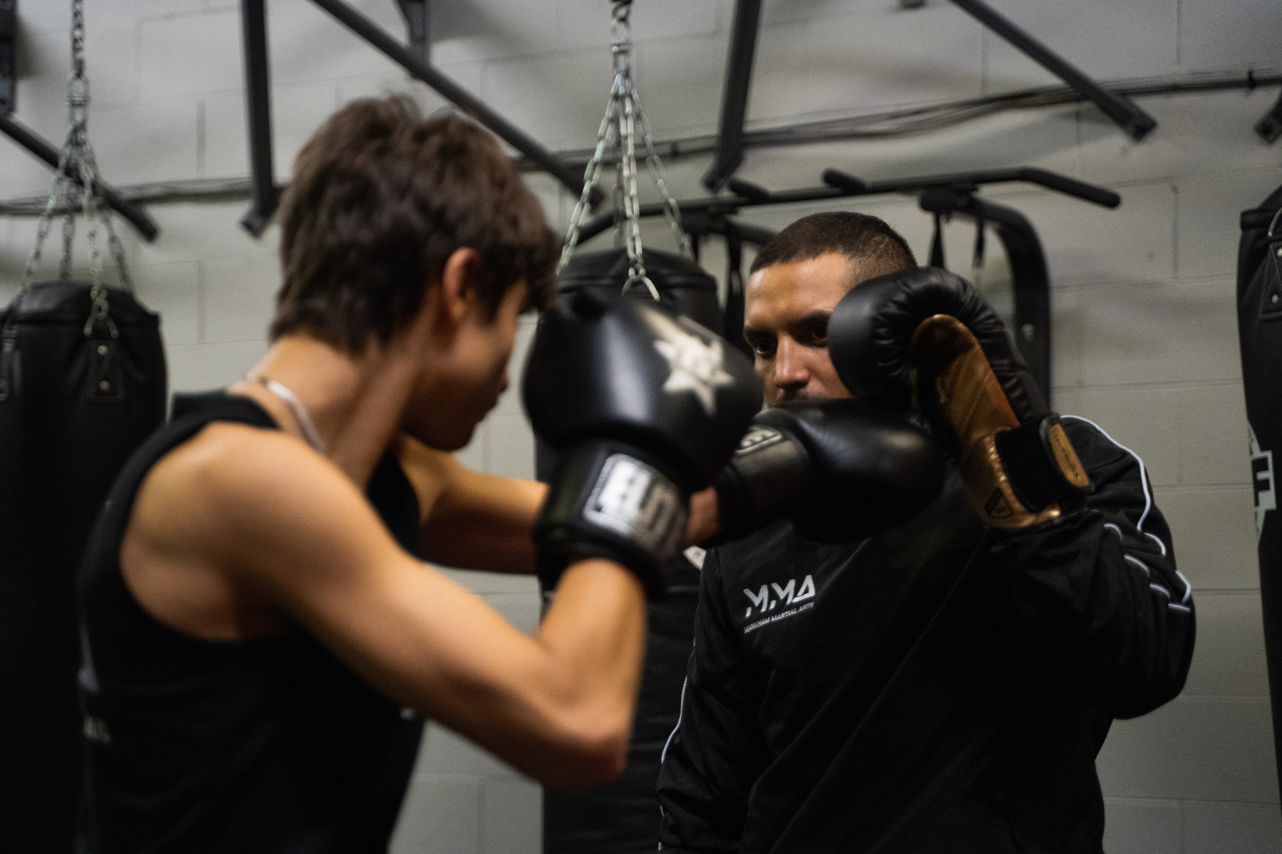 Kru Christopher Williams holding pads for a Muay Thai student at Elite Fight Club