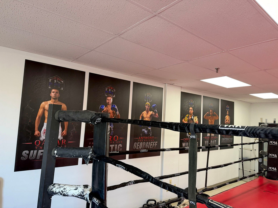 The boxing ring and fighter portrait wall inside Elite Fight Club