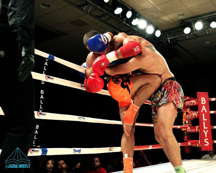 Two Muay Thai fighters working in the clinch in the ring
