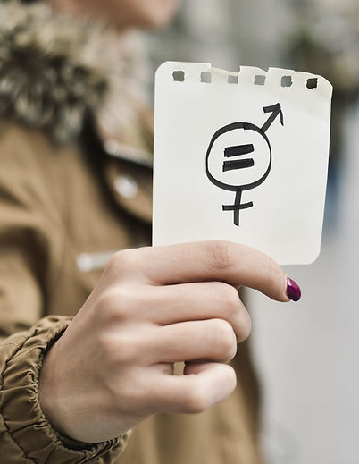 A person holds up a note that says all genders are equal