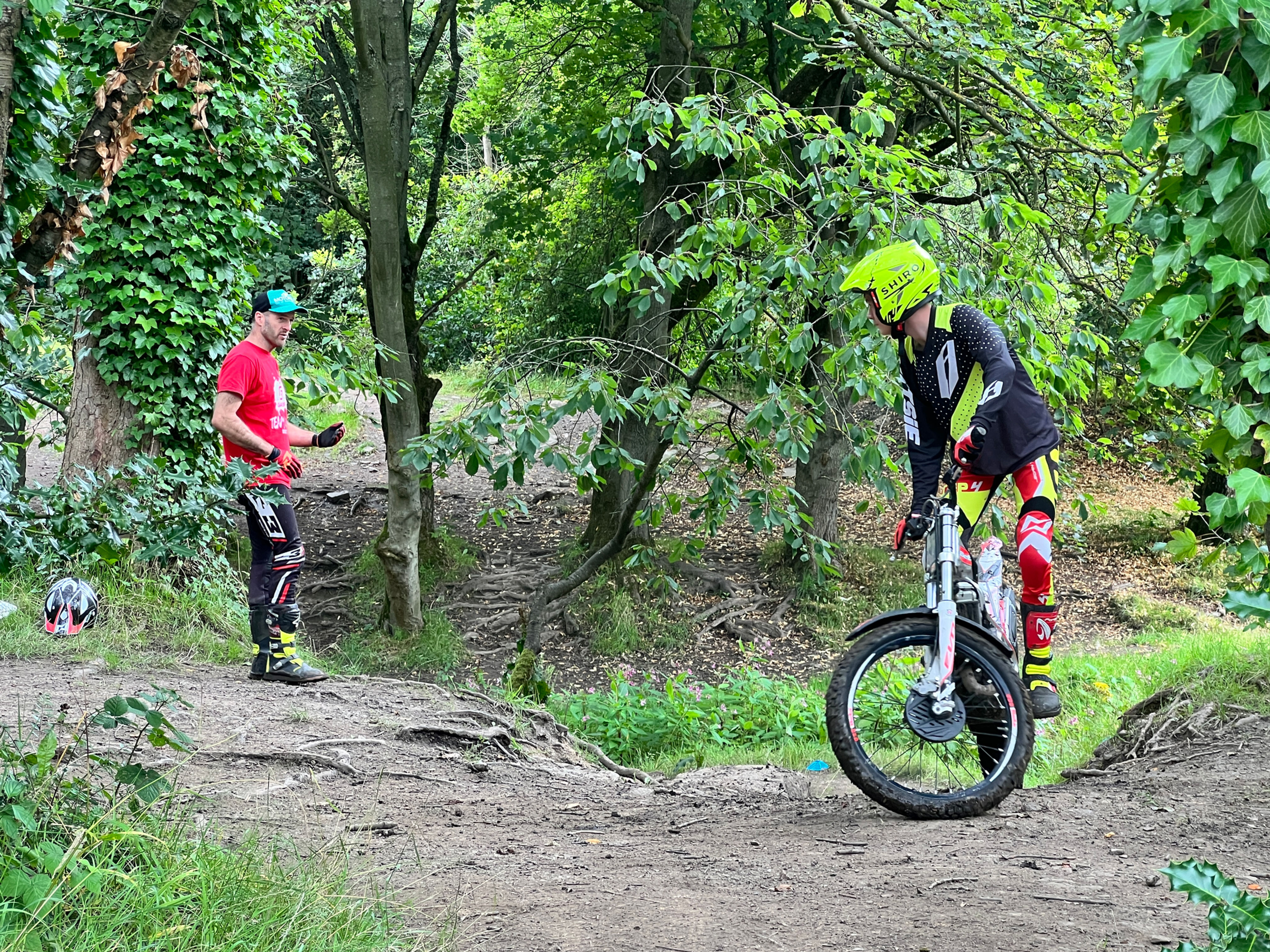 Dan Thorpe stood next to a man on a trials motorcycle on an off road park